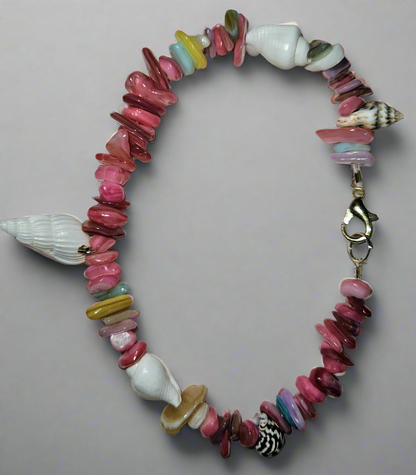 Colorful beaded bracelet with shell elements on a light gray background